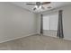 Comfortable bedroom with neutral carpet, ceiling fan and window with curtains offers a peaceful retreat at 1162 E Ranch Ct, Gilbert, AZ 85296