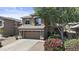 Inviting two-story home with stone accents, a two-car garage, mature landscaping, and a blooming pink bush at 1162 E Ranch Ct, Gilbert, AZ 85296