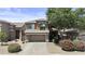 Beautiful two-story home featuring a two-car garage, stone accents, tidy landscaping, and mature shade trees at 1162 E Ranch Ct, Gilbert, AZ 85296
