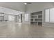 Open living area features tile flooring, neutral walls, built-in shelves, and an adjacent kitchen and dining area at 1162 E Ranch Ct, Gilbert, AZ 85296