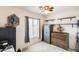 Cozy bedroom with a ceiling fan, natural light from window, and safe in the corner at 12318 W Bloomfield Rd, El Mirage, AZ 85335