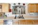 Charming kitchen showcasing wood cabinets and a stainless steel dishwasher at 12318 W Bloomfield Rd, El Mirage, AZ 85335