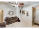 Inviting living room featuring a cozy sofa, tile floors, and decorative wall art at 12318 W Bloomfield Rd, El Mirage, AZ 85335