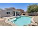 Backyard pool with tanning deck and spillover featuring an outdoor dining set and outdoor grill on the patio at 12318 W Bloomfield Rd, El Mirage, AZ 85335