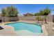 Backyard kidney-shaped pool with tanning deck, mature landscaping, and a rock waterfall feature at 12318 W Bloomfield Rd, El Mirage, AZ 85335