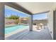 View of the backyard pool with waterfall feature and covered patio area with dining set, perfect for outdoor entertaining at 12318 W Bloomfield Rd, El Mirage, AZ 85335