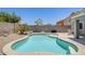Kidney-shaped pool with tanning deck and rock waterfall feature in a well landscaped backyard with a block wall at 12318 W Bloomfield Rd, El Mirage, AZ 85335
