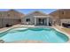 Backyard pool with tanning deck featuring an outdoor dining set and covered patio, perfect for relaxing outdoors at 12318 W Bloomfield Rd, El Mirage, AZ 85335
