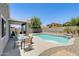 Outdoor dining set with a pool featuring a rock waterfall in this well landscaped backyard at 12318 W Bloomfield Rd, El Mirage, AZ 85335