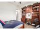 Bright bedroom featuring a built-in desk and shelving unit, with hardwood floors at 1247 E Bautista Rd, Gilbert, AZ 85297