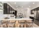 Stylish kitchen with dark cabinets, quartz countertops, a breakfast bar, and stainless steel appliances at 1247 E Bautista Rd, Gilbert, AZ 85297