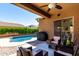 Covered patio with outdoor seating overlooking the sparkling pool at 1247 E Bautista Rd, Gilbert, AZ 85297