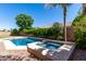 A backyard featuring a pool and hot tub with a brick fence and plants at 1247 E Bautista Rd, Gilbert, AZ 85297