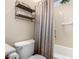 Bathroom with toilet and tub/shower combo behind shower curtain, includes overhead shelving at 13219 W Santa Ynez Dr, Sun City West, AZ 85375