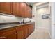 Well-appointed butler's pantry with custom cabinetry, granite countertops, and wine storage at 13219 W Santa Ynez Dr, Sun City West, AZ 85375