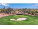 Scenic aerial view of the golf course showcasing a sand trap and green with mountain views in the background at 13219 W Santa Ynez Dr, Sun City West, AZ 85375