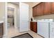 Laundry room with washer, dryer, sink and cabinet. Includes doorway to the toilet at 13219 W Santa Ynez Dr, Sun City West, AZ 85375