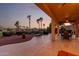 Covered patio with seating, lush greenery, and sunset views at 13219 W Santa Ynez Dr, Sun City West, AZ 85375