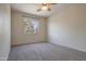 Unfurnished bedroom with ceiling fan, carpet and view of treed neighborhood at 1335 E June St # 221, Mesa, AZ 85203