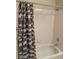 Clean white tiled shower and bath with a decorative shower curtain at 1335 E June St # 221, Mesa, AZ 85203