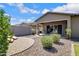 Backyard with desert landscaping, including a built in fire pit, covered patio, and a desert rock border at 1364 W Spine Tree Ave, Queen Creek, AZ 85140