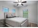 Comfortable bedroom features neutral tones, a ceiling fan, and natural light from the windows at 1364 W Spine Tree Ave, Queen Creek, AZ 85140