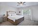 Primary bedroom showcases a wood-frame bed, with a decorative headboard, plush pillows and a ceiling fan at 1364 W Spine Tree Ave, Queen Creek, AZ 85140