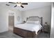 Primary bedroom showcases a wood-frame bed, with a decorative headboard, plush pillows and a ceiling fan at 1364 W Spine Tree Ave, Queen Creek, AZ 85140
