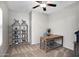 Cozy home office with a ceiling fan, desk, shelving, and carpet floors, offering a quiet workspace at 1364 W Spine Tree Ave, Queen Creek, AZ 85140