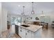 Modern kitchen with an island, stainless steel appliances, granite countertops and an adjacent living area at 1364 W Spine Tree Ave, Queen Creek, AZ 85140