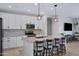 Bright kitchen features granite countertops, stainless appliances, white cabinets, and a pendant lit breakfast bar at 1364 W Spine Tree Ave, Queen Creek, AZ 85140