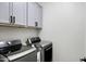 Convenient laundry room features modern washer and dryer with overhead cabinets for ample storage at 1364 W Spine Tree Ave, Queen Creek, AZ 85140