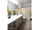 Bathroom featuring double sinks, gray cabinets, and yellow-striped shower curtain at 1364 W Spine Tree Ave, Queen Creek, AZ 85140