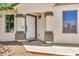A close-up of the inviting front entrance with white door, stone accents, and manicured desert landscape at 1384 E Leslie Ave, San Tan Valley, AZ 85140