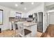 Bright kitchen features stainless steel appliances, white cabinets, and an island with bar seating at 1384 E Leslie Ave, San Tan Valley, AZ 85140