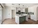 Bright kitchen boasts white cabinetry, stainless steel appliances, and an island with quartz countertop at 13862 W Fargo Dr, Surprise, AZ 85374