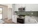 Contemporary kitchen features stainless steel appliances, white cabinets and a tile backsplash at 13862 W Fargo Dr, Surprise, AZ 85374