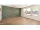 Minimalist room featuring a custom-designed accent wall with light wood floors and ample natural light at 13862 W Fargo Dr, Surprise, AZ 85374