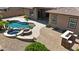 Aerial view of the backyard featuring a pool, spa, covered patio, and desert landscaping at 14572 W Medlock Dr, Litchfield Park, AZ 85340