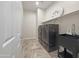 Functional laundry room with modern washer and dryer, built-in shelves, and utility sink at 14572 W Medlock Dr, Litchfield Park, AZ 85340