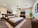 Spacious bedroom features a large bed, ceiling fan, and lots of natural light at 14572 W Medlock Dr, Litchfield Park, AZ 85340