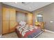Bedroom featuring built-in wardrobe, tile flooring, neutral walls, and a window with blinds at 15928 W Zinnia Ct, Surprise, AZ 85374