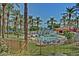 Resort-style community pool area with palm trees, lounge chairs, and water features for relaxation and recreation at 15928 W Zinnia Ct, Surprise, AZ 85374