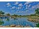 Scenic golf course view featuring a pond with waterfall and lush landscaping under a blue sky at 15928 W Zinnia Ct, Surprise, AZ 85374