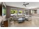 Bright living room featuring a large sectional sofa, modern ceiling fan, and views of the outdoor patio at 15928 W Zinnia Ct, Surprise, AZ 85374