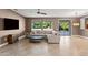 Open-concept living room with neutral tones, tiled floors, and sliding door access to outdoor patio at 15928 W Zinnia Ct, Surprise, AZ 85374