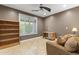 This living room offers a ceiling fan and natural light from the large window at 15928 W Zinnia Ct, Surprise, AZ 85374