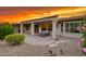 Covered patio with a seating area and desert landscaping providing a tranquil outdoor living space at sunset at 15928 W Zinnia Ct, Surprise, AZ 85374