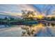 Tranquil pond reflecting a picturesque sunset, creating a peaceful and scenic outdoor view at 15928 W Zinnia Ct, Surprise, AZ 85374