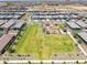 Aerial shot showcases a well-kept park with a playground, bordered by sidewalks and neighboring homes at 16004 W Honeysuckle Dr, Surprise, AZ 85387